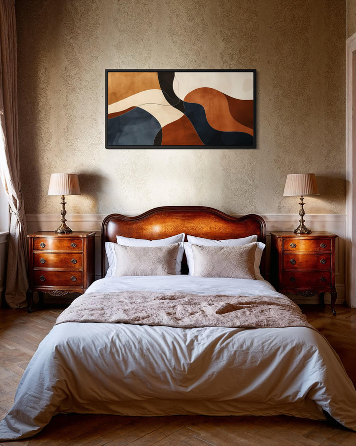 Mid Century abstract canvas print with earth tone curves in brown, beige, and navy above a bed.