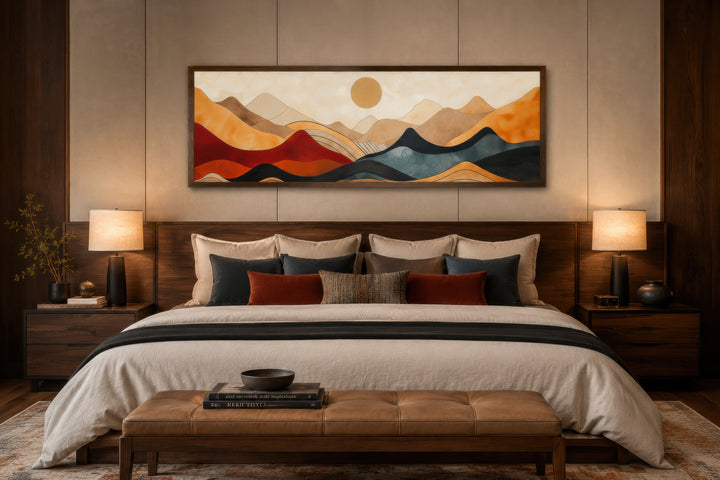 Mid-century modern horizontal mountain canvas wall art in a dark wood frame above a bed.