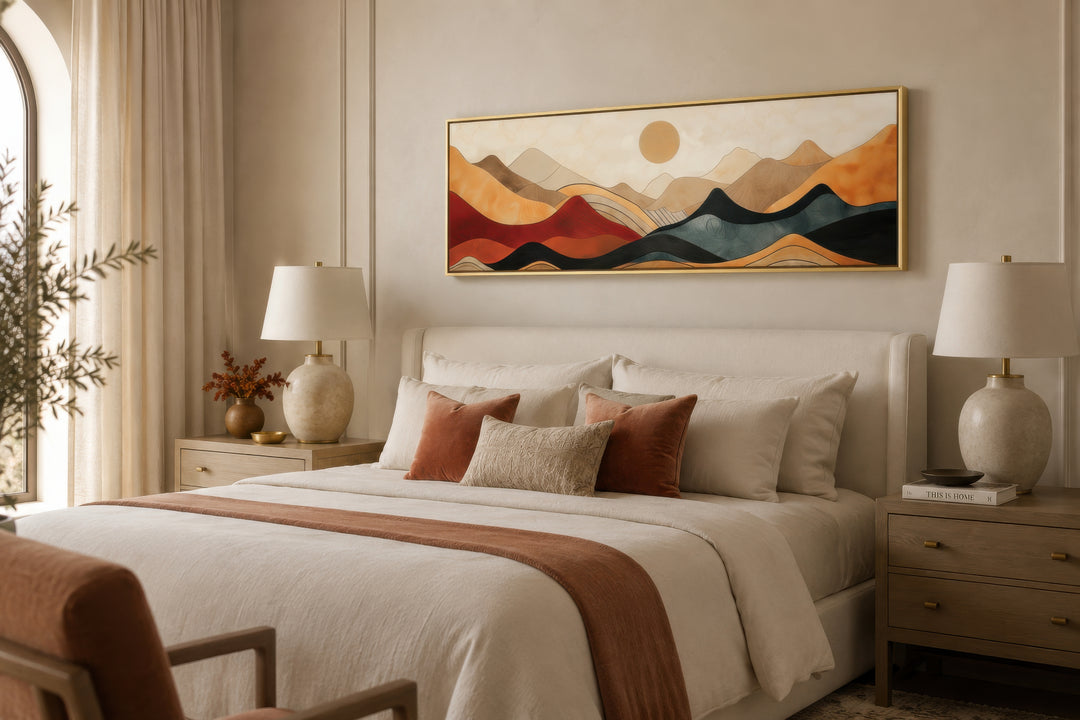 Long horizontal mid-century modern mountain canvas wall art in a gold frame above a bed.