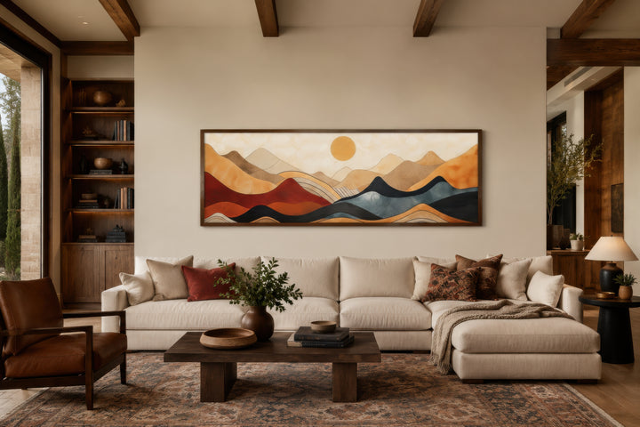 Vintage mid century modern long horizontal mountain canvas wall art above a cream sectional sofa.