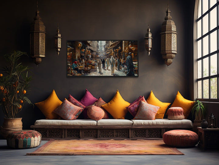 Middle Eastern fruit bazaar framed canvas wall art hanging above a low wooden sofa with pillows.