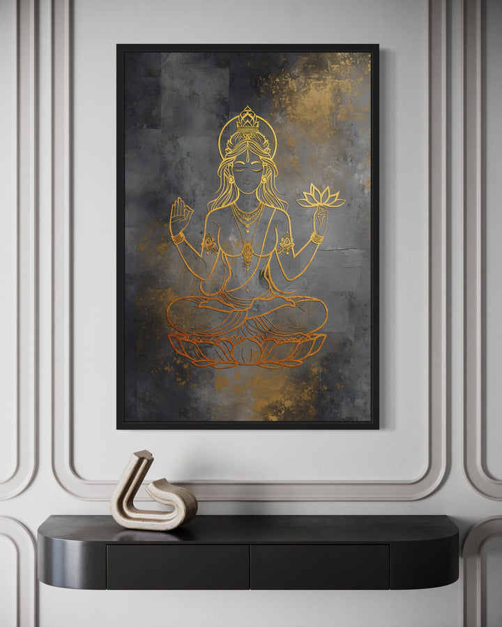 Minimalist gold Lakshmi goddess line art on a dark textured framed canvas above a black console.