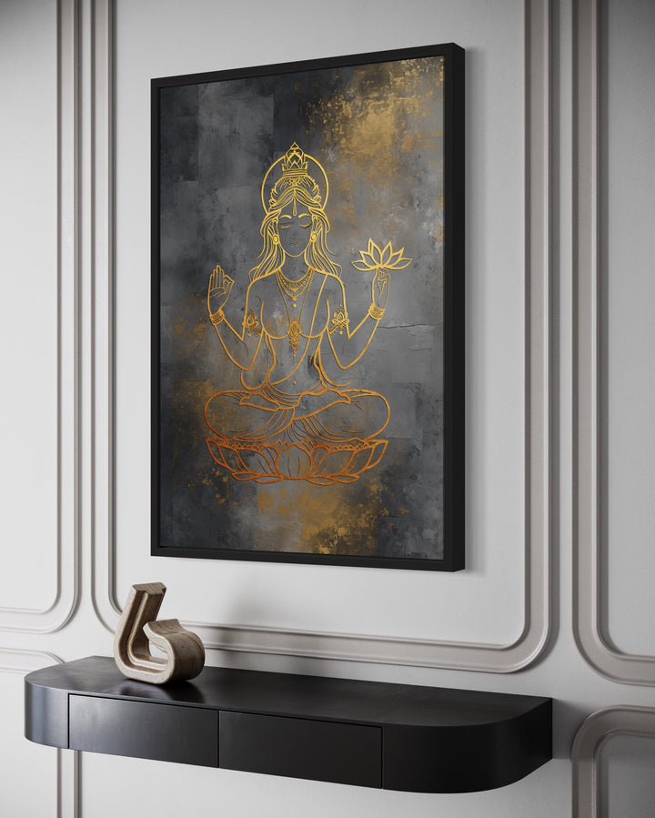 Minimalist gold Lakshmi goddess line art on a dark gray textured framed canvas above a black console.