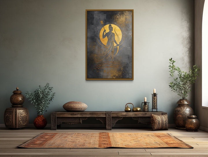 Minimalist Lord Rama framed canvas wall art in gold and silver tones above a rustic wooden bench.