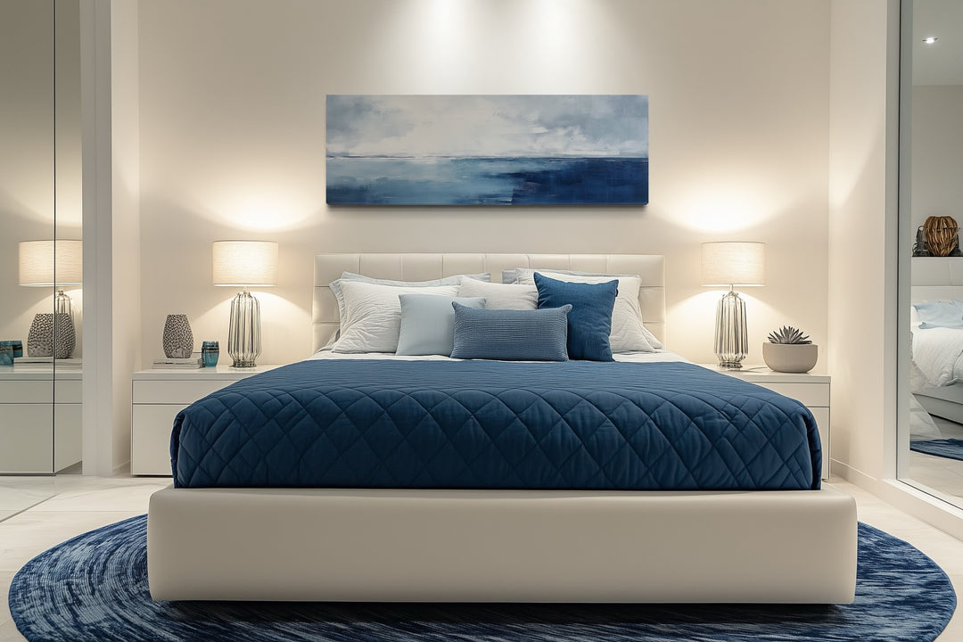 Minimalist ocean navy blue and grey panoramic framed canvas wall art above a modern bed.