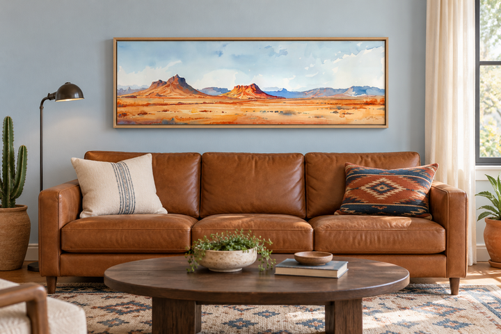 Horizontal framed canvas wall art of a minimalist Arizona desert landscape above a leather sofa.