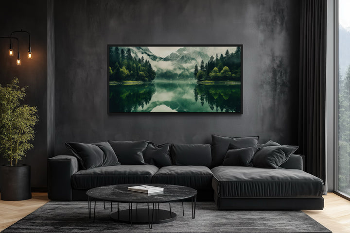 Emerald green canvas wall art of a mirror lake and mountains in a dark modern living room.