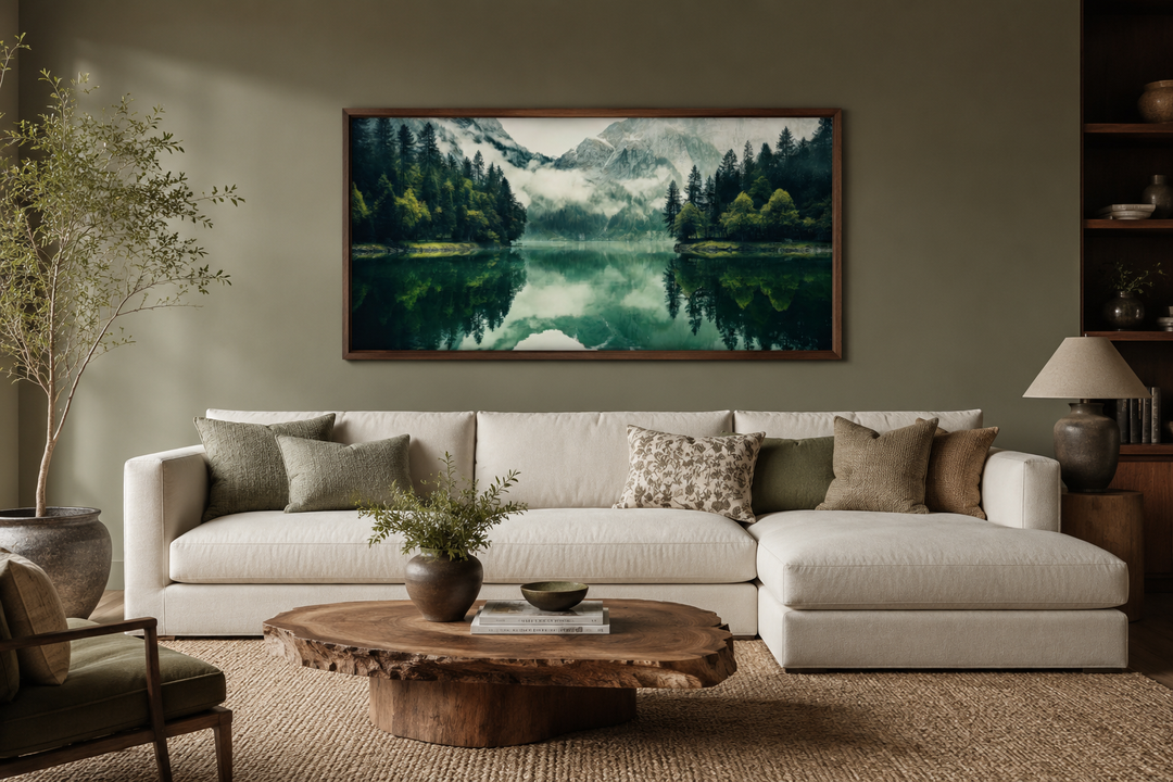Emerald green canvas wall art of a mirror lake and mountains above a white sofa in a living room.