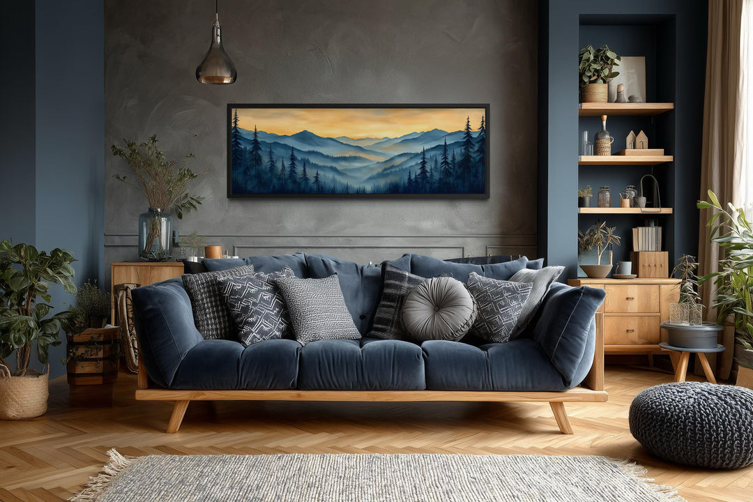 Misty mountain forest sunset long horizontal canvas wall art above a blue sofa in a modern room.