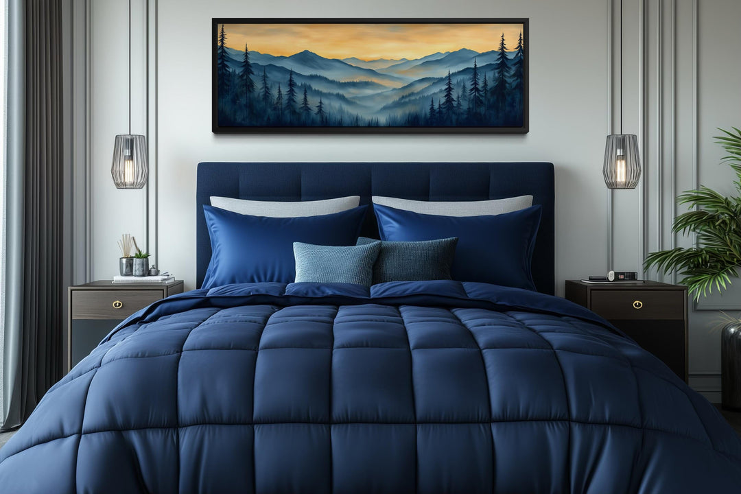 Misty mountain forest sunset long horizontal canvas wall art displayed above a blue bed.