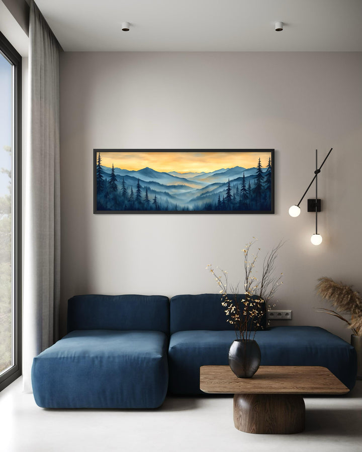 Misty mountain forest sunset long horizontal canvas wall art above a blue sofa in a modern room.