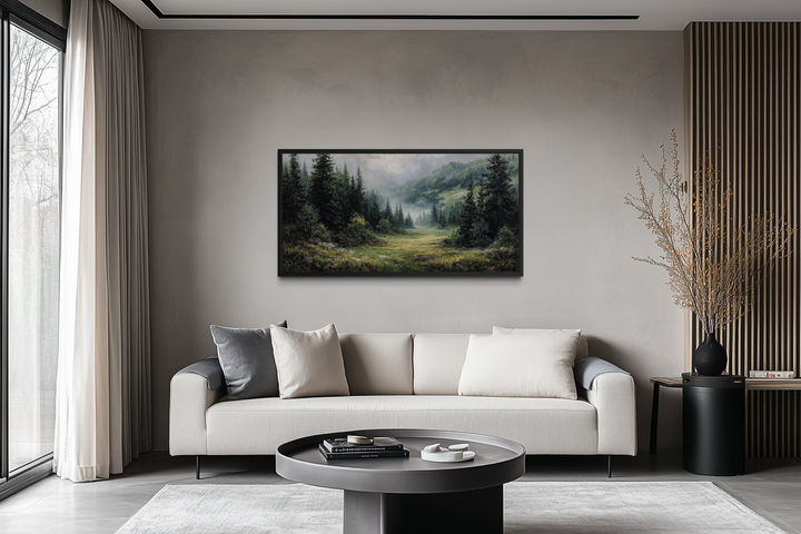 A panoramic canvas of a misty mountain meadow and pine forest hangs above a modern cream sofa.