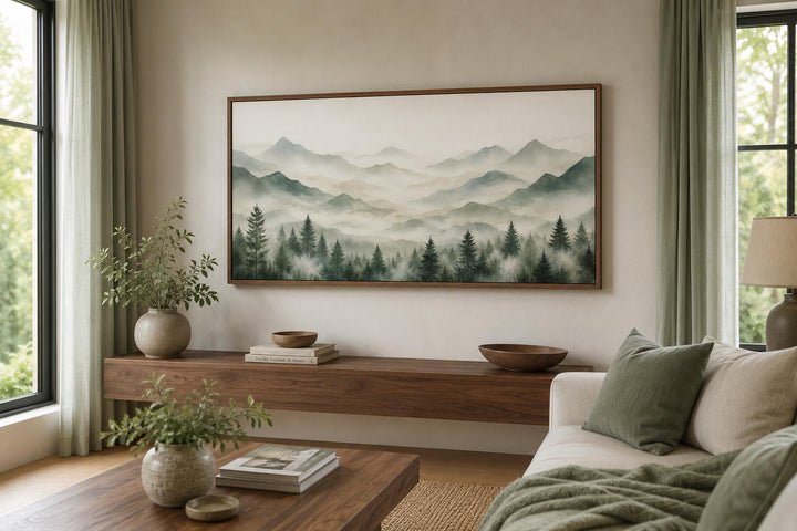 Misty mountain and sage green pine tree canvas wall art in a wood frame above a console table.