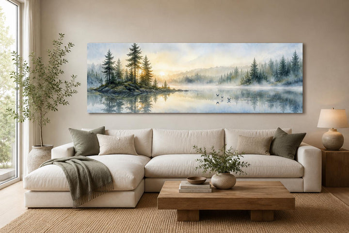 Panoramic misty pine forest and serene lake canvas print above a white sectional sofa.