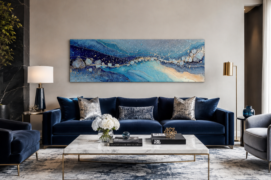 Modern long horizontal blue and navy abstract canvas art hanging above a velvet sofa in a room.