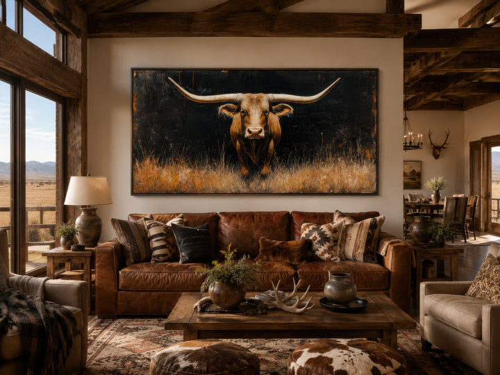 Modern Texas longhorn steer in the grass framed canvas wall art above a brown leather sofa.