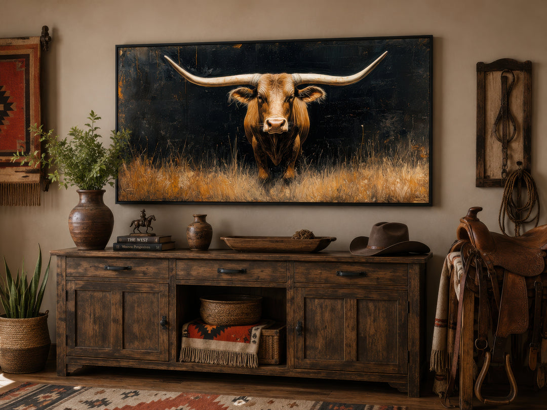 Modern Texas longhorn steer in grass framed farmhouse canvas wall art above a rustic wooden console.
