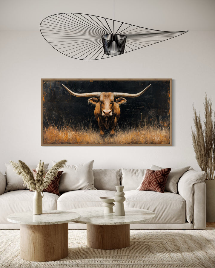 Modern Texas longhorn steer in grass framed farmhouse canvas wall art above a white sofa.