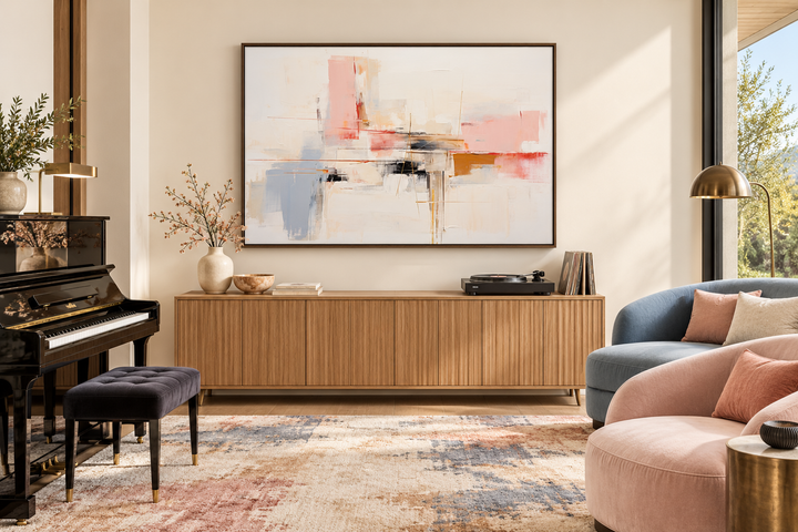 Modern abstract canvas wall art with blush pink, cream, and blue tones in a wood-framed living room.