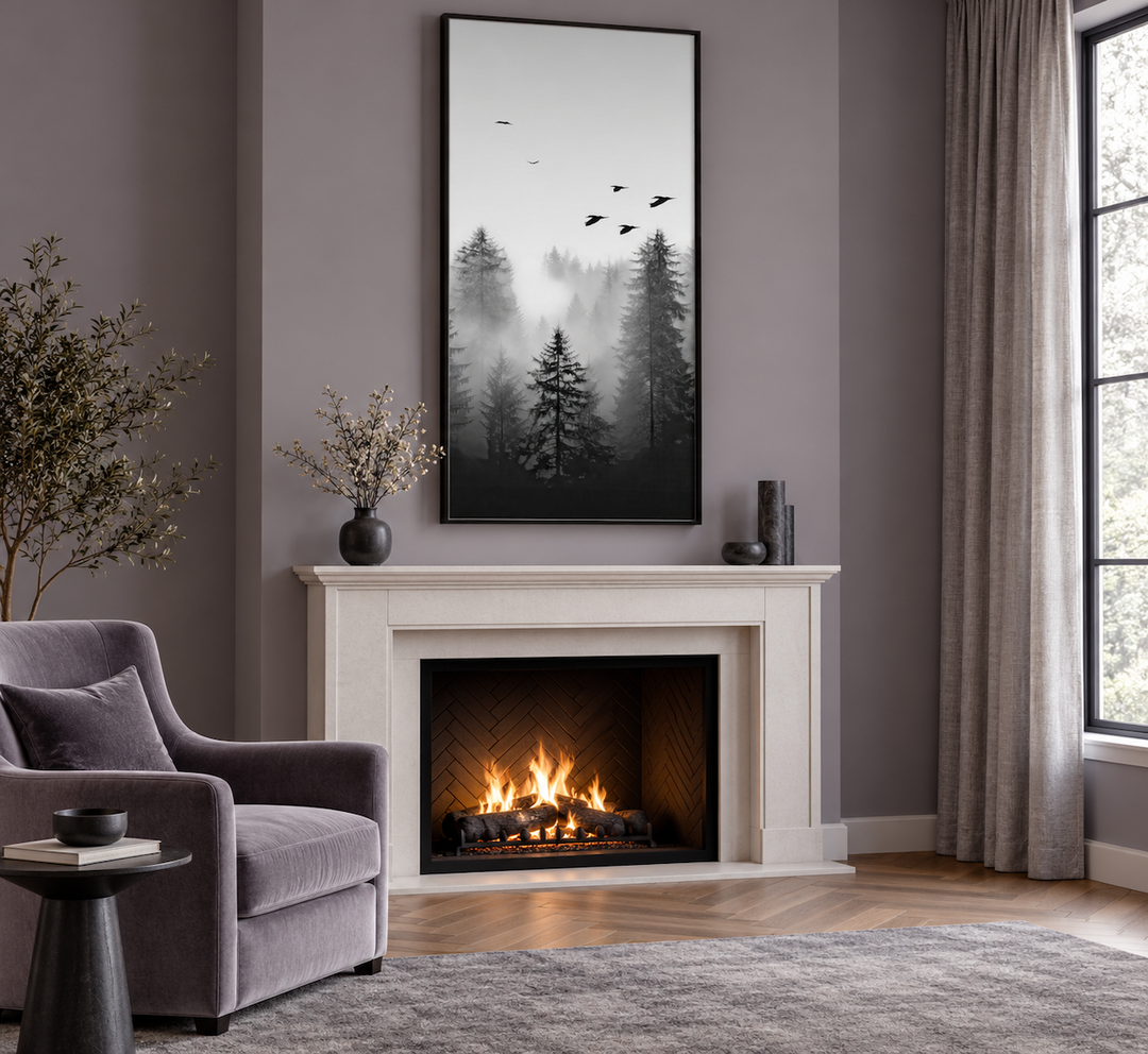 Tall vertical black and white canvas art of a foggy fir tree forest hanging above a fireplace.