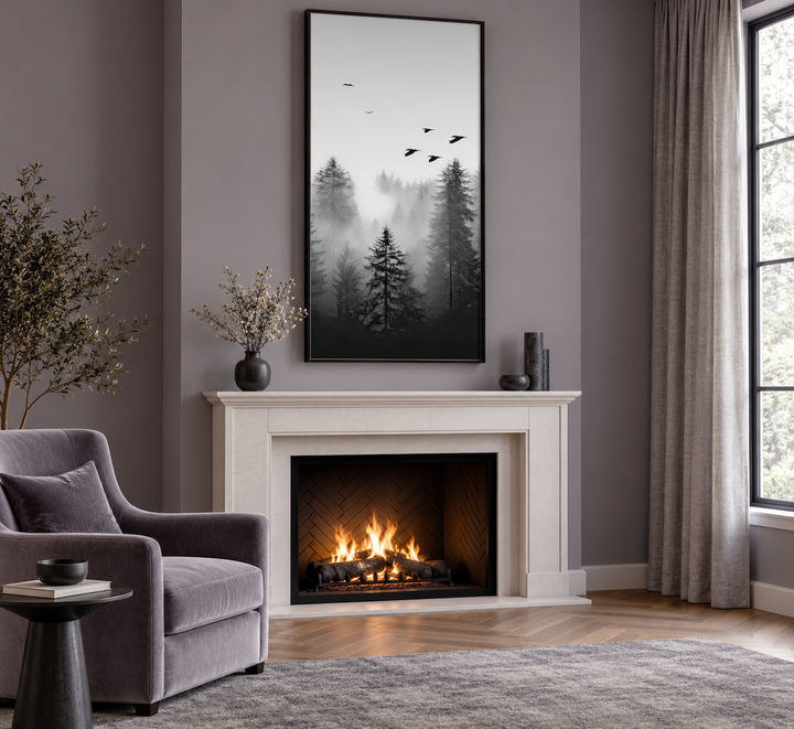 Tall vertical black and white canvas art of a foggy fir tree forest hanging above a fireplace.