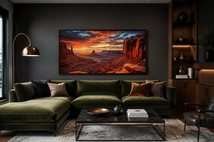 Monument Valley Sunset Framed Canvas Wall Art above a green velvet sofa in a modern living room.