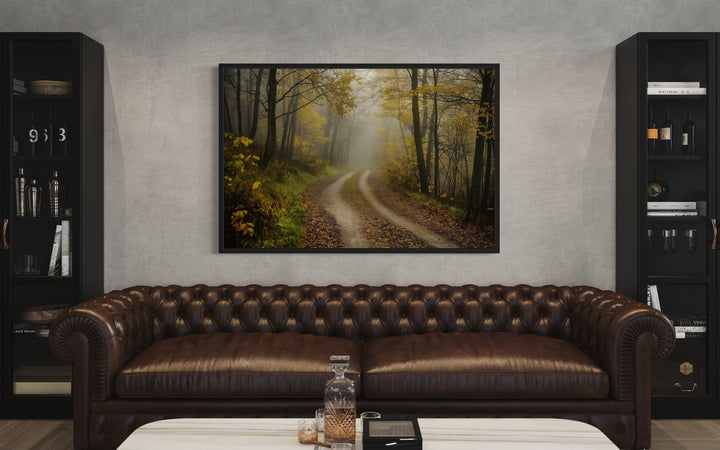 Moody Foggy Autumn Forest Framed Canvas Wall Art hanging above a brown leather sofa.