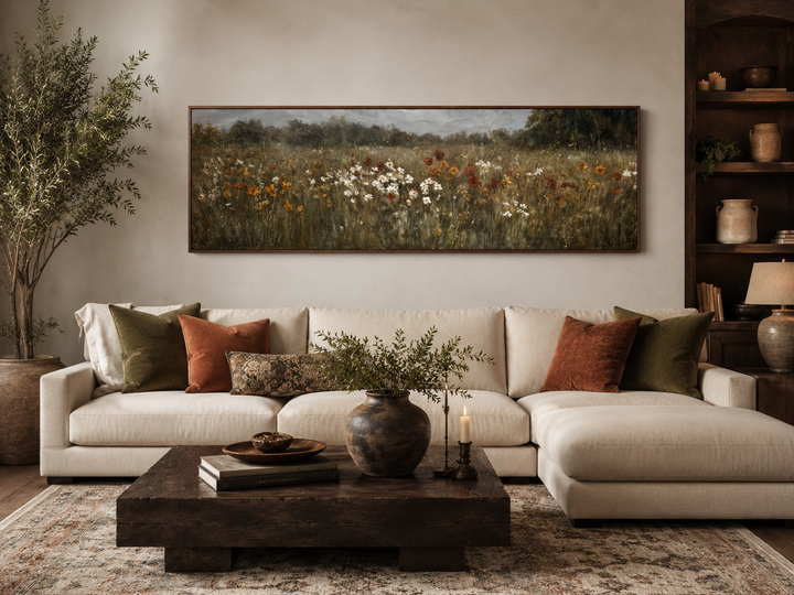 Moody muted wildflower field long horizontal canvas art above a sofa in a neutral living room.
