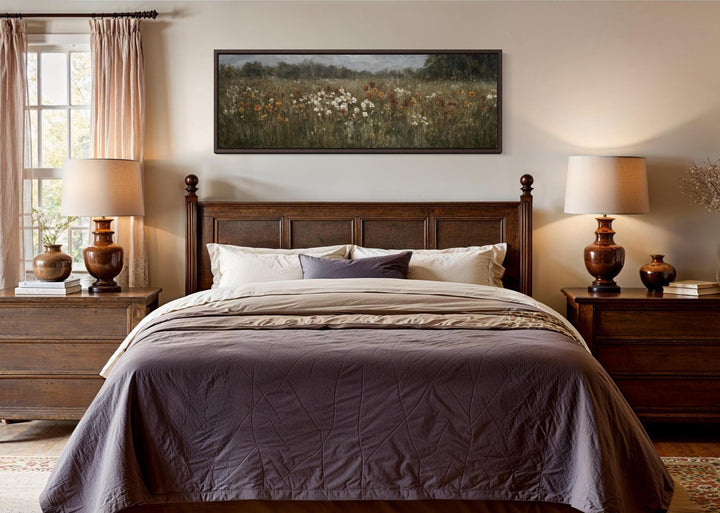 A long horizontal canvas of a muted wildflower field hangs above a dark wood bed in a cozy bedroom.
