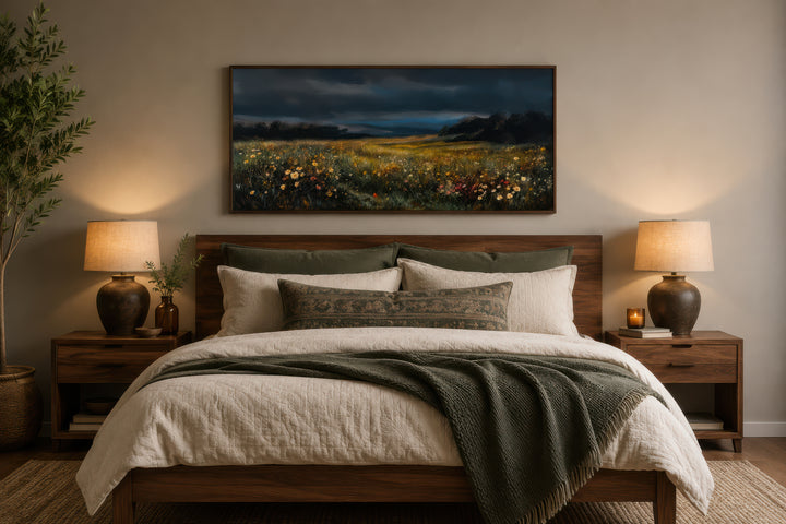 Moody Wildflowers Meadow At Night Canvas Wall Art in a dark wood frame above a bed.