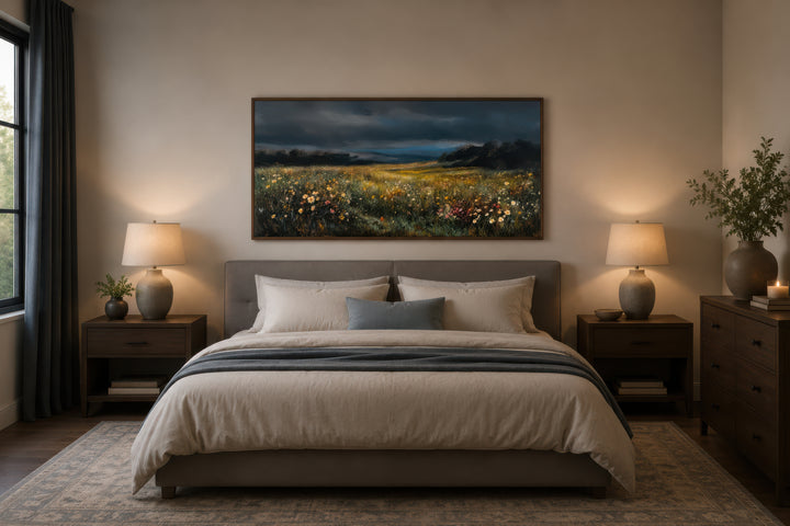Moody wildflowers meadow at night canvas wall art hanging above a bed in a neutral bedroom.