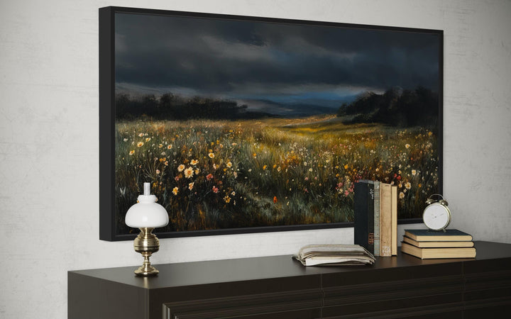 Moody wildflowers meadow at night canvas wall art in a black frame above a dark wood dresser.