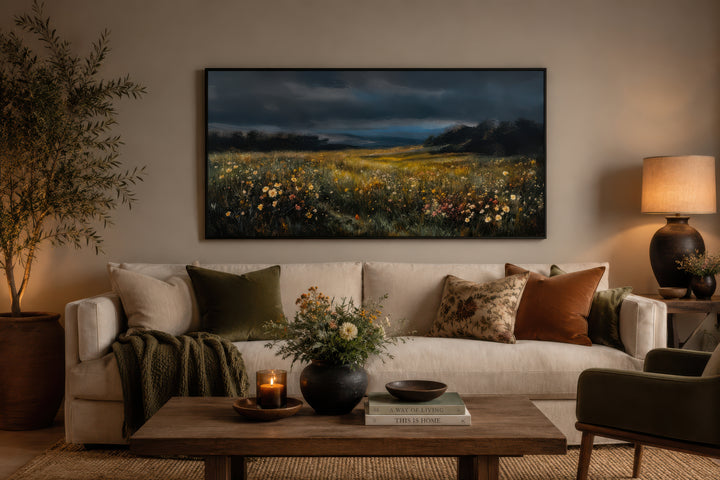 Moody wildflowers meadow at night canvas wall art above a cream sofa in a cozy living room.