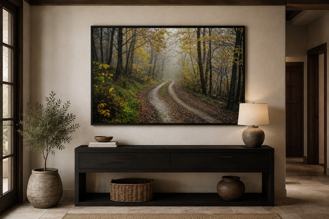 Moody foggy autumn forest framed canvas wall art hanging above a dark wood console table.
