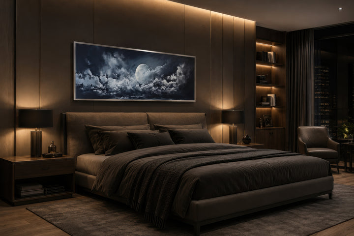Moon and cloudy sky horizontal framed canvas wall art hanging above a bed in a dark bedroom.