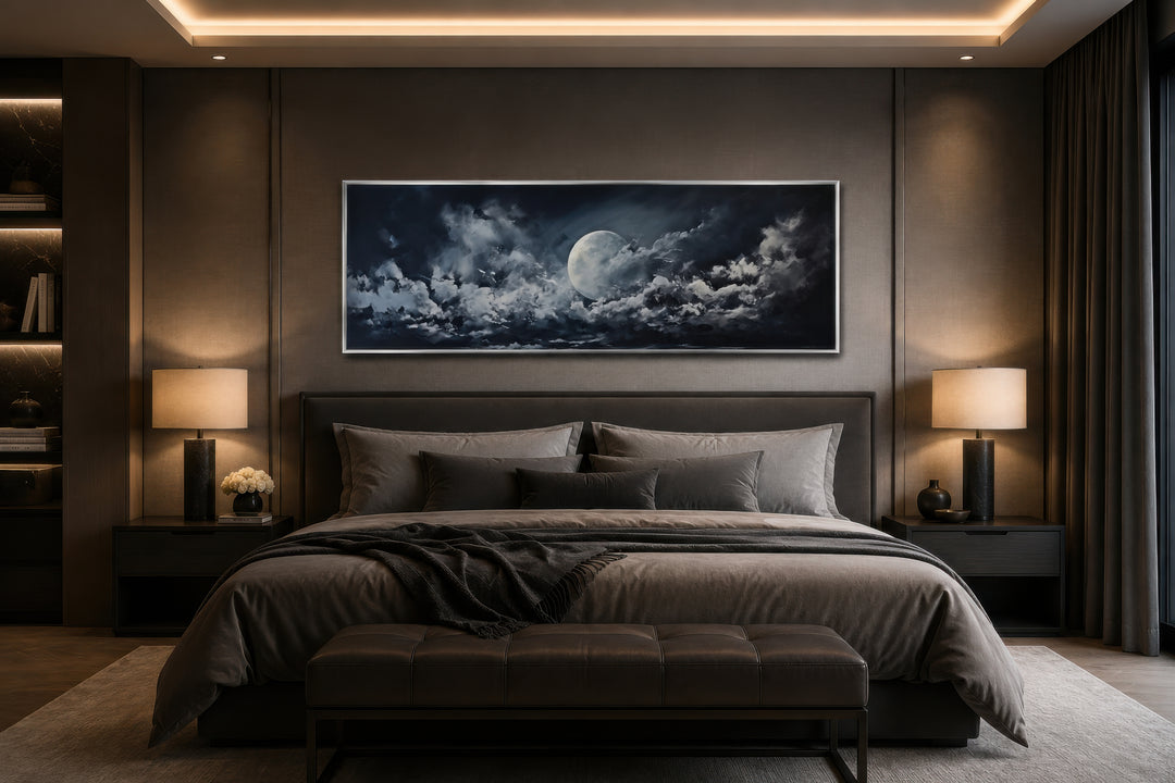 Horizontal framed canvas wall art of a glowing moon and clouds above a bed in a modern bedroom.