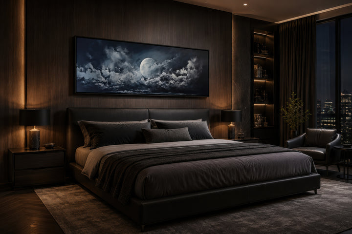 Moon and cloudy sky horizontal framed canvas wall art hanging above a bed in a dark bedroom.