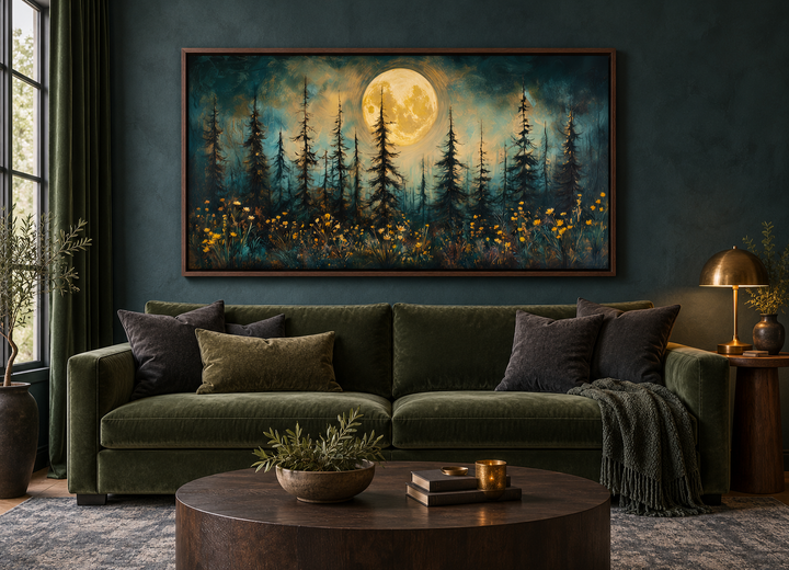 Mystical moonlit forest and wildflowers painting in a rustic walnut frame above a green sofa.