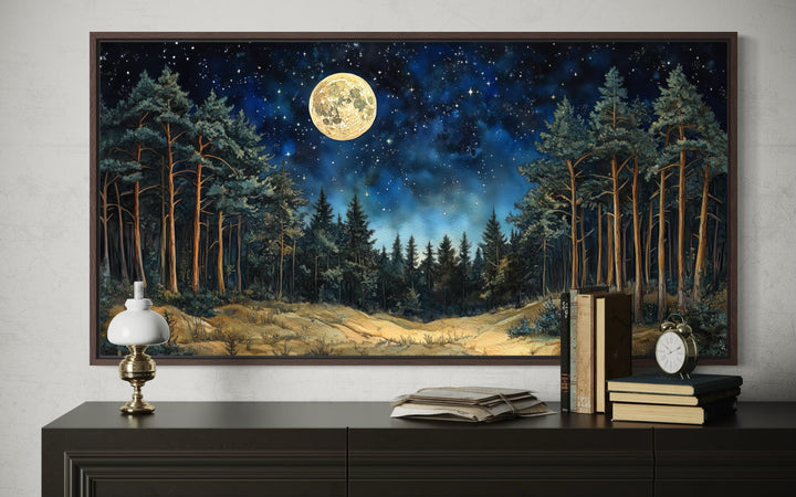 Horizontal wall art of a moonlit pine forest under a starry sky above a dark wooden dresser.