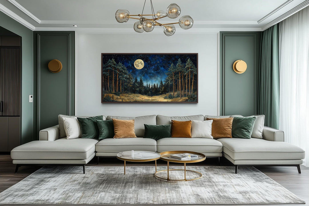 Horizontal wall art of a moonlit pine forest above a modern sofa in a stylish living room.