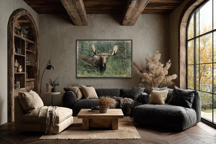 Moose in the forest wall art painting on canvas in a rustic living room with wood beams.