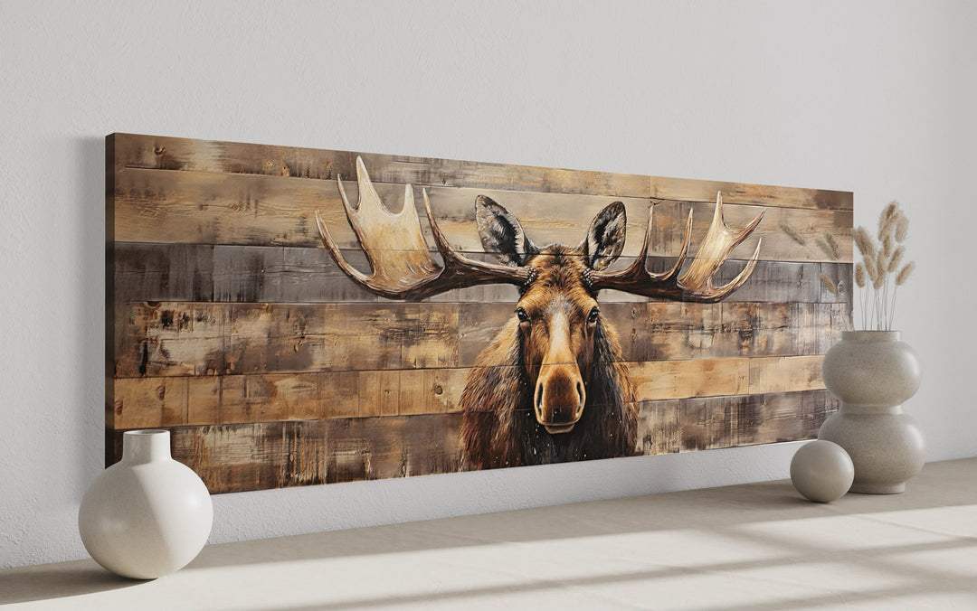 Moose painted on rustic wood-textured horizontal canvas wall art in a modern room setting.