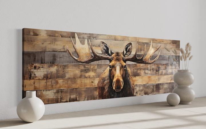 Moose painted on rustic wood-textured horizontal canvas wall art in a modern room setting.