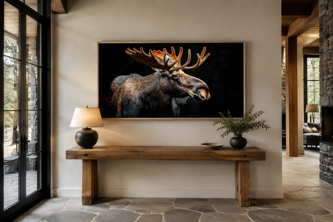 Extra large framed moose wall art on a black background in a rustic cabin living room.