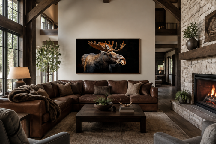 Extra large framed moose canvas wall art in a rustic living room with a leather sofa and fireplace.
