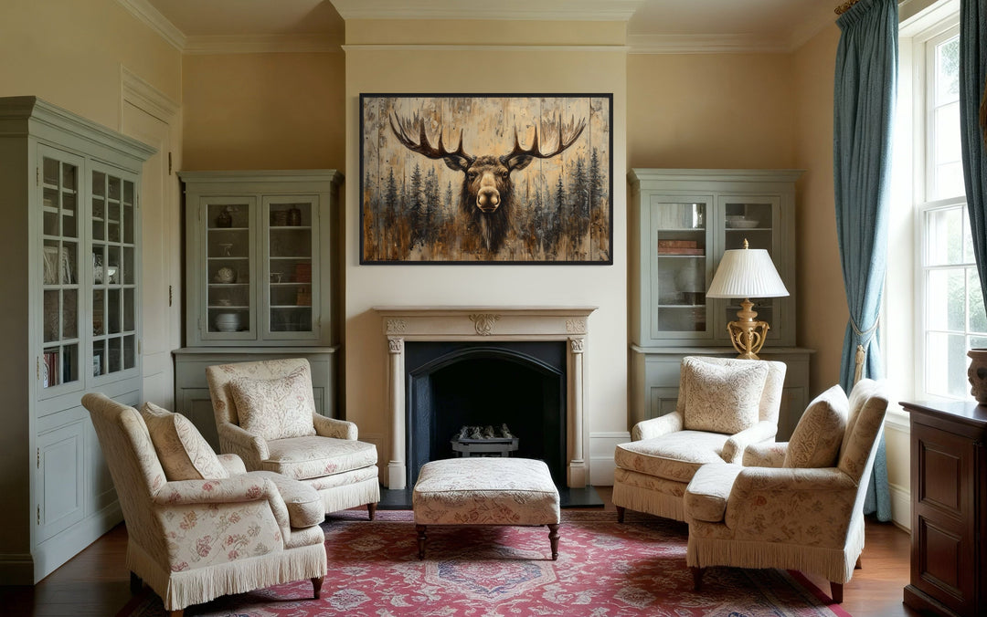 Moose portrait on wood-look framed canvas wall art hanging above a fireplace in a rustic living room.