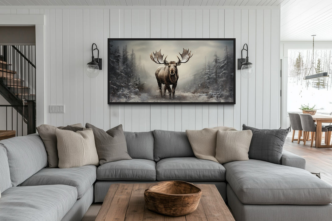 Moose in a foggy winter forest framed canvas wall art hanging above a gray sectional sofa.