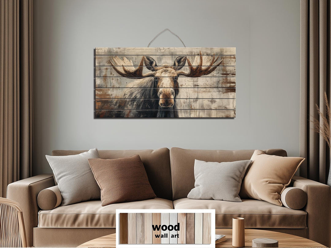Rustic moose wall art printed on horizontal wood planks hanging above a neutral-toned sofa.