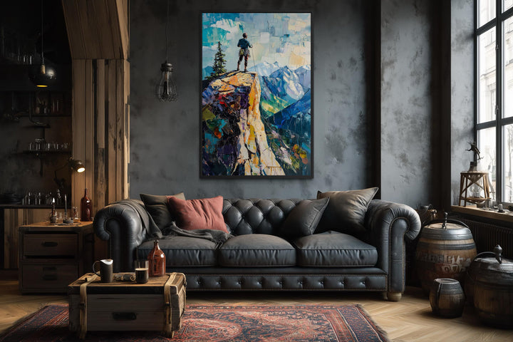 Vertical canvas print of a hiker on a cliff landscape in a moody, industrial-style living room.