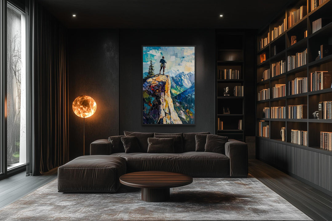 Vertical canvas print of a hiker on a cliff landscape in a modern, dark-toned living room.
